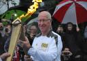 Sir Bobby Charlton receives the flame.