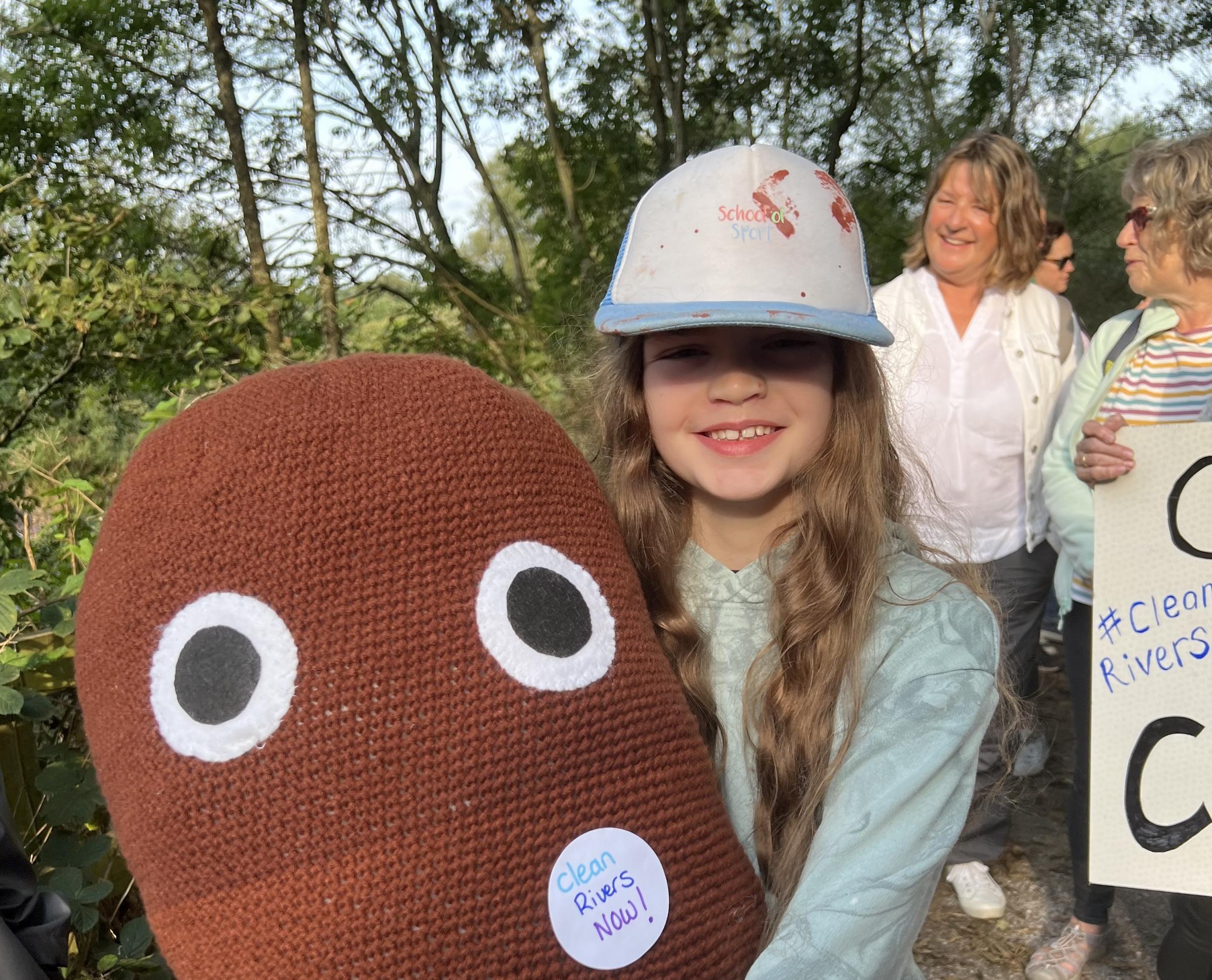 Ivy, 10, dons her giant knitted poo during the protest