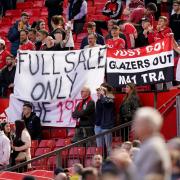 Protesters hold banners in Old Trafford at a previous match