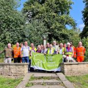 Councillors Stephen Adshead, Simon Thomas, and Barry Winstanley, with Friends of Davyhulme Park, raising the Green Flag banner