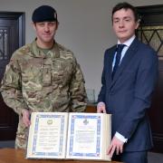 Cllr Anstee and Staff Sgt Matt Spruce of the 207 Field Regiment with the Stretford book of remembrance