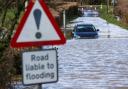 A car is stuck in floodwater  (Steve Parsons/PA)