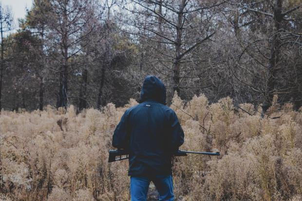 Man in woods with a firearm