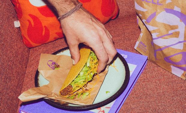 Messenger Newspapers: A person picking up a Crunchy Taco (Taco Bell)
